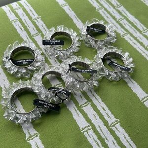 KIM SEYBERT NAPKIN RINGS - set of 7, clear lucite crystals w metal ring. Tag on.